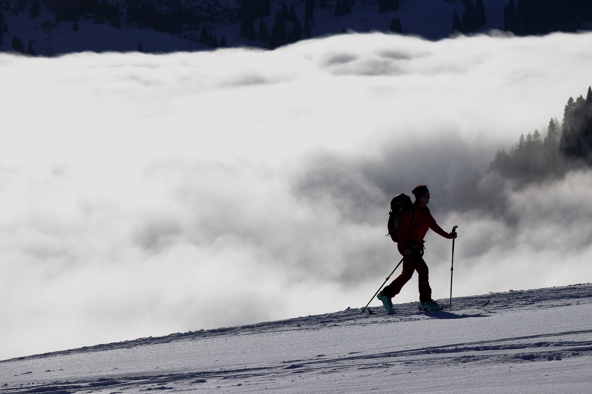 A picture of a woman climbing a mountain, with clouds in the background