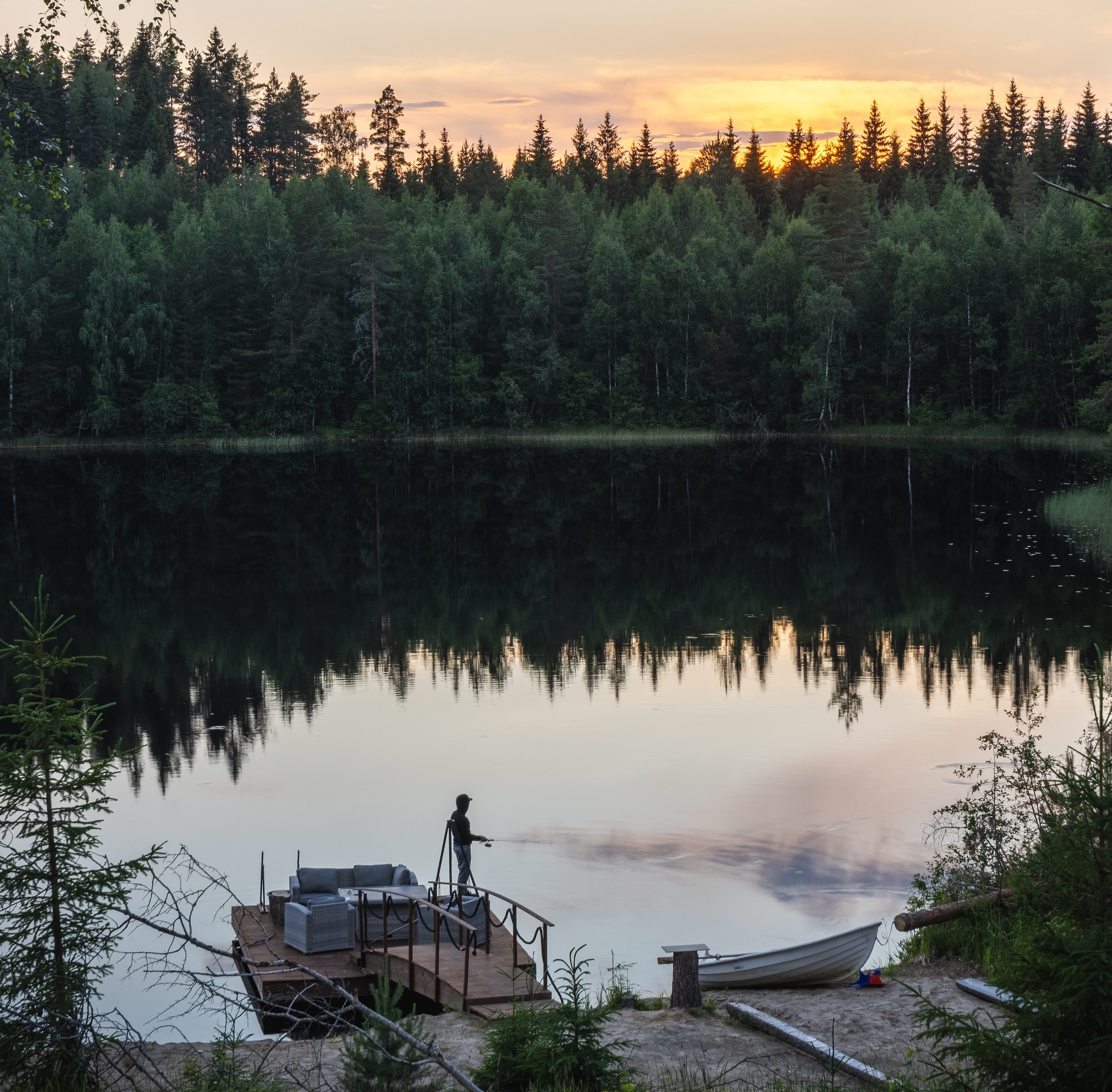 a man fishing at a lake at sunset, esl-tree.com